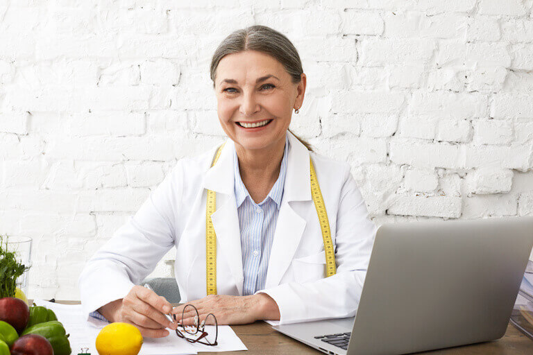 A smiling female nutrition coach is ready to support a client.