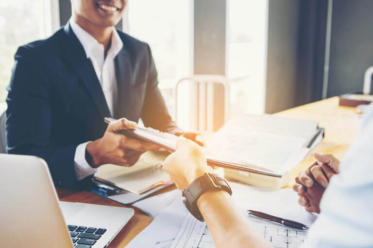 Smiling person in suit handling documents