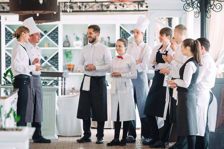 Restaurant staff speaking with the head chef.
