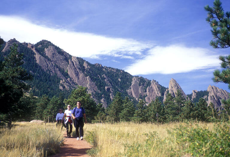 Three people hiking with mountains in the background